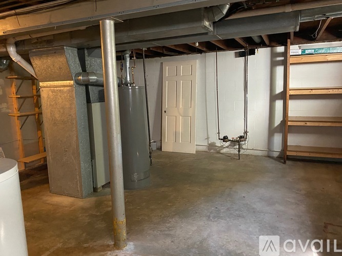 A room with a white door, a grey column, and a white tank.
