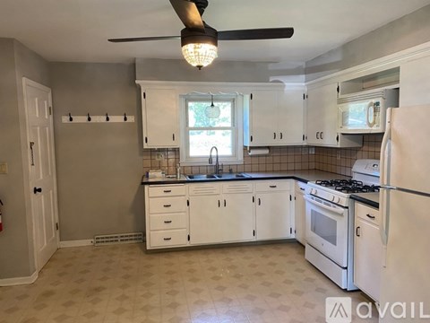 A kitchen with white cabinets and a black stove top.