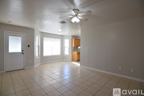 A spacious room with a ceiling fan and tiled flooring.