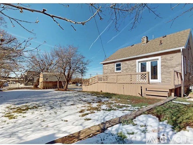 A house with a snow-covered ground in front of it.