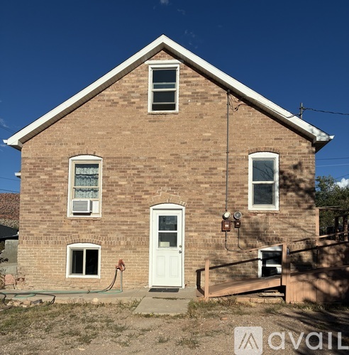 A brick house with a white door and windows.