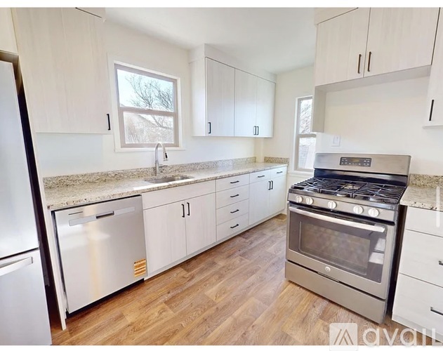 A kitchen with white cabinets and a stainless steel oven.