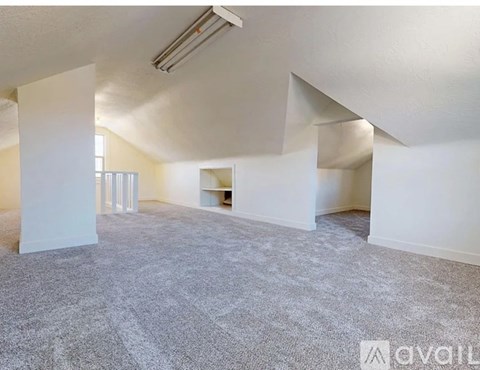 A spacious room with carpeted floor and white walls.