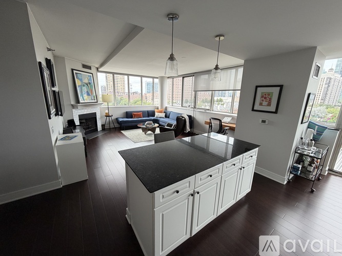 A spacious kitchen with white cabinets and a black countertop.