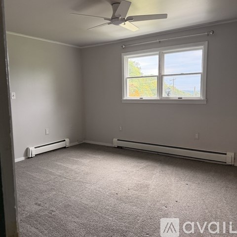 A room with a window and a ceiling fan.
