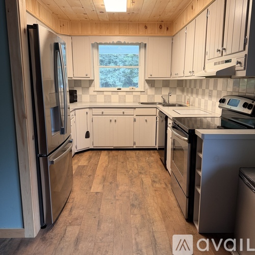 A kitchen with wooden cabinets and a window.