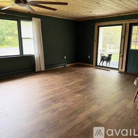 A room with wooden flooring and a ceiling fan.