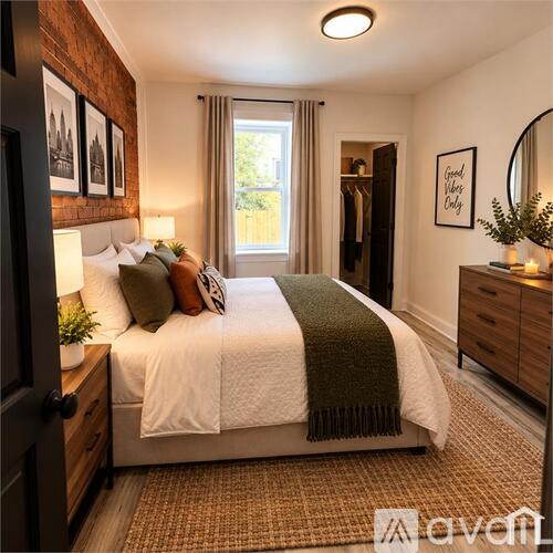 A bedroom with a bed, a mirror, and a window with curtains.