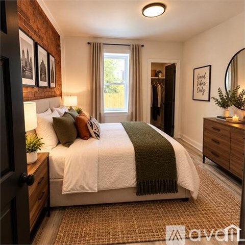 A bedroom with a bed, a mirror, and a window with curtains.