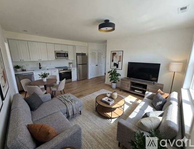 A living room with a grey couch and a coffee table in the middle.