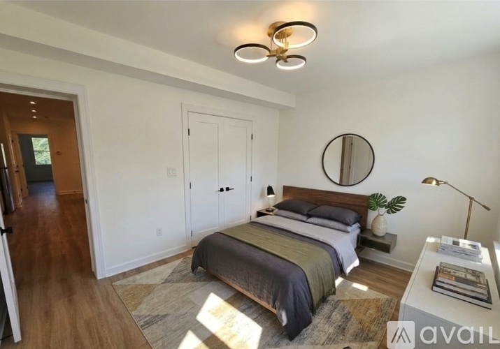 A bedroom with a bed, nightstand, and a lamp.
