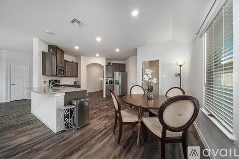 A modern kitchen with a dining table set for four.