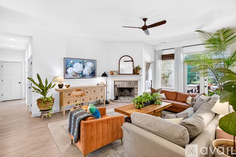 A living room with a fireplace and a painting on the wall.