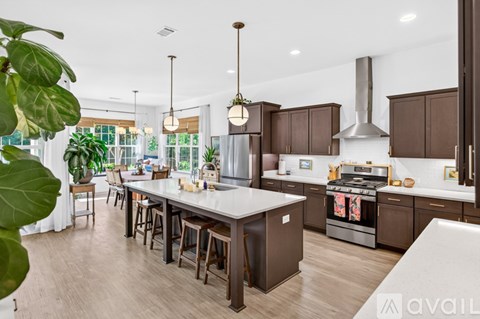 A modern kitchen with brown cabinets and a white island.
