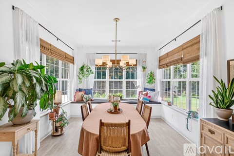 A dining room with a round table surrounded by chairs.