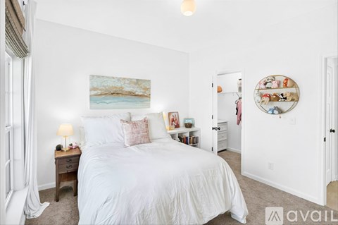 A bedroom with a large bed and a painting on the wall.