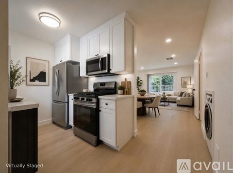 A modern kitchen with stainless steel appliances and white cabinets.