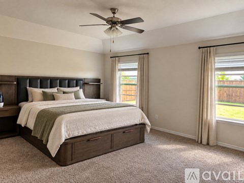 A bedroom with a large bed and a ceiling fan.
