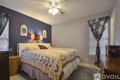A bedroom with a bed, nightstand, and window.