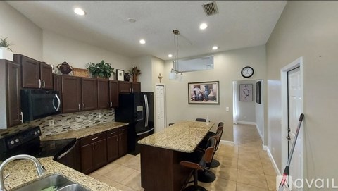 A kitchen with brown cabinets and granite countertops.