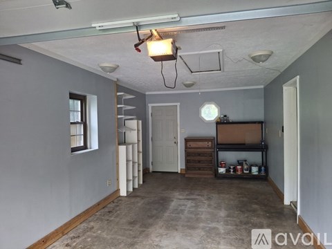 A room with a white door and a window on the left side.