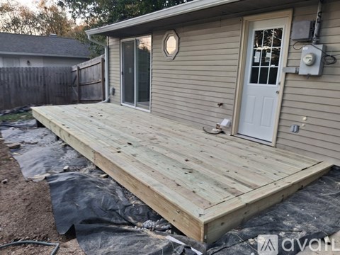 A wooden deck is being built in a backyard.