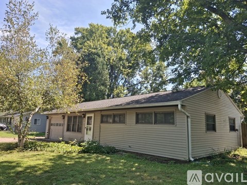 A house is for sale in a sunny suburban area.