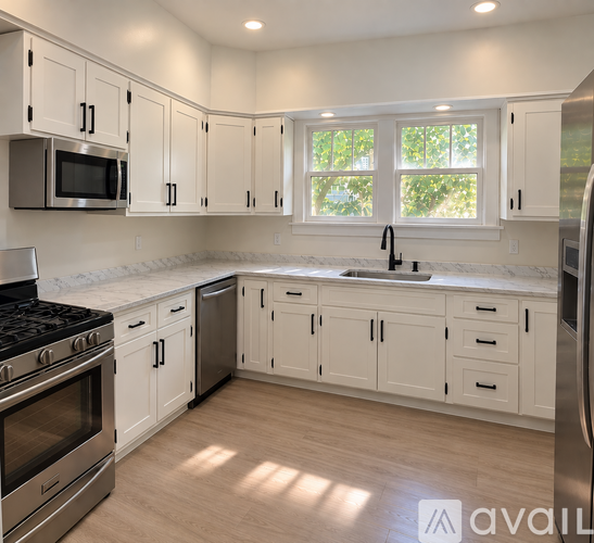 A kitchen with white cabinets and a stainless steel refrigerator.