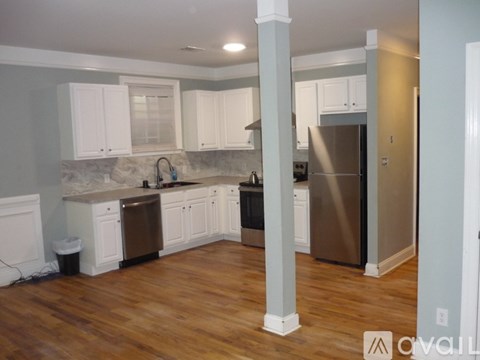 A kitchen with white cabinets and a stainless steel refrigerator.