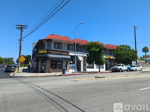 A street view with a building, cars, and a yellow sign.