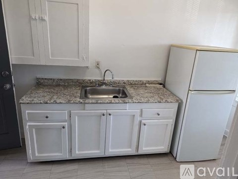 A kitchen with white cabinets and a granite countertop.