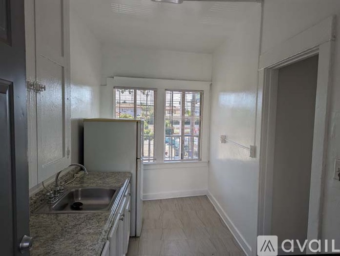 A kitchen with granite countertops and a window overlooking a street.