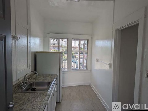 A kitchen with granite countertops and a window overlooking a street.