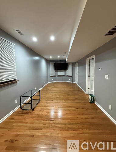 A long hallway with wooden floors and a black metal object on the floor.