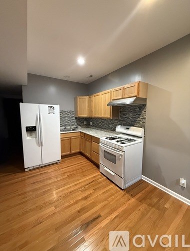 A kitchen with wooden floors and a white refrigerator.