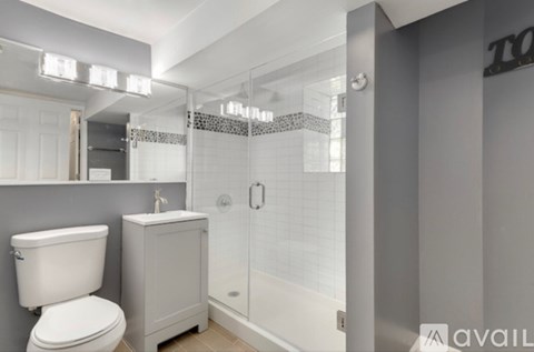 A bathroom with a toilet, sink, and shower.
