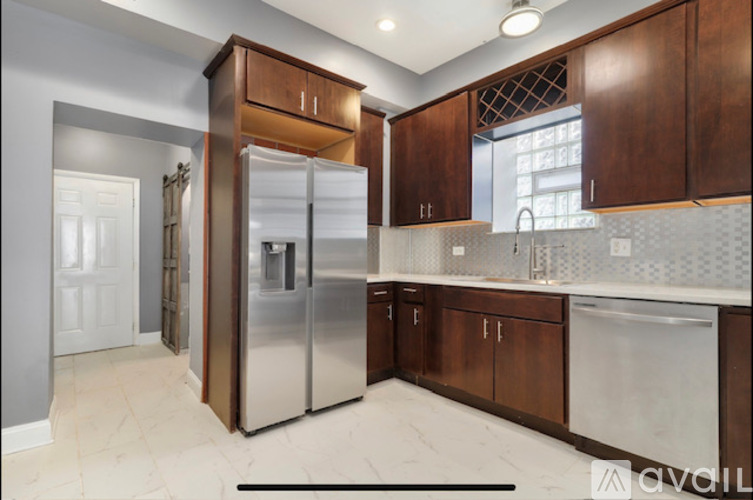 A kitchen with a refrigerator, cabinets, and a countertop.