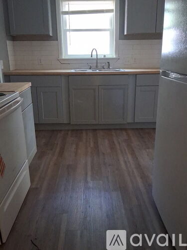 A kitchen with wooden floors and white appliances.