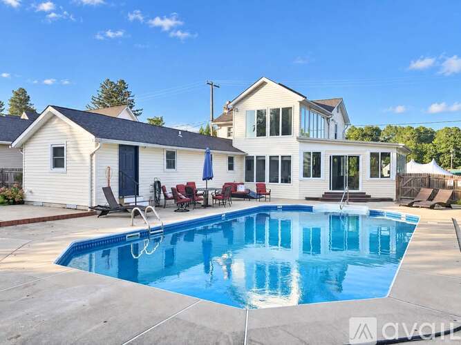 A large house with a swimming pool in front.
