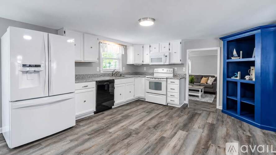 A kitchen with white appliances and a blue cabinet.