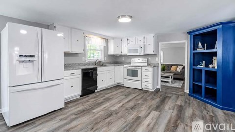A kitchen with white appliances and a blue cabinet.