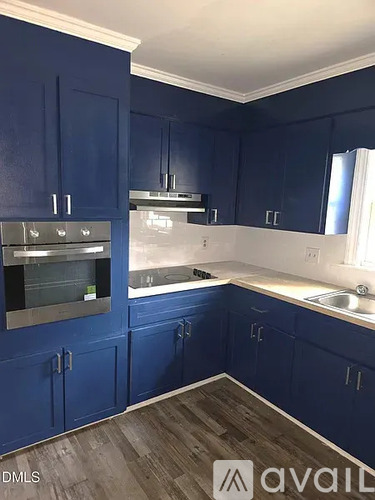 A kitchen with blue cabinets and a stove top oven.