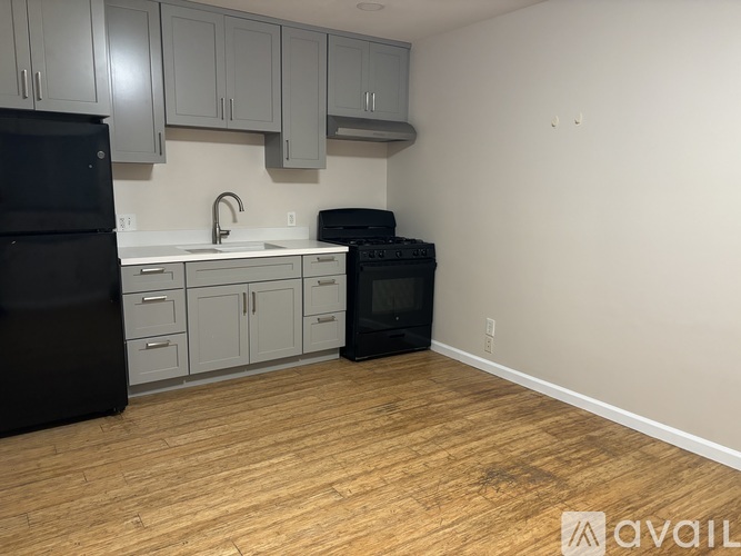 A kitchen with a black fridge and black microwave oven.