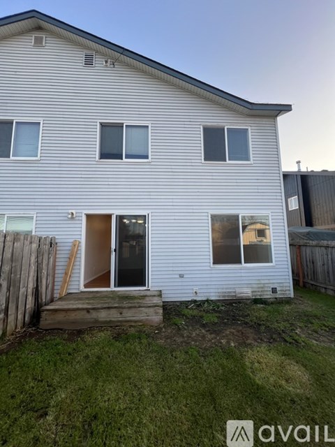 A house with a grey siding and a brown door.