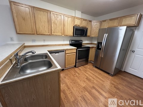A kitchen with wooden cabinets and stainless steel appliances.