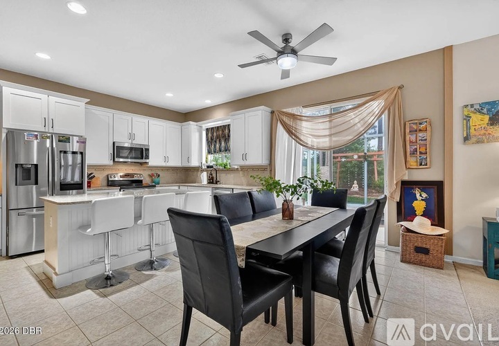 A kitchen with a dining table and chairs.
