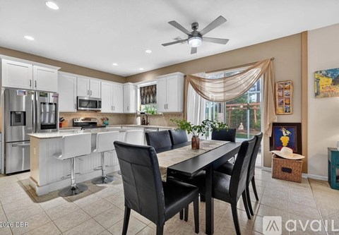 A kitchen with a dining table and chairs.
