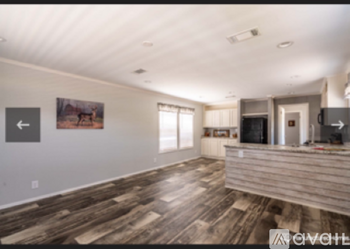 A living room with wood flooring and a painting on the wall.