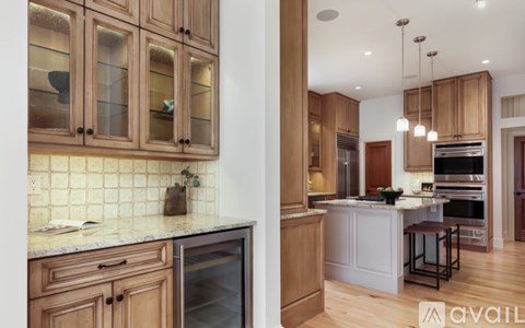 A kitchen with wooden cabinets and a marble countertop.