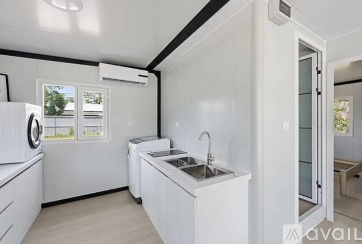A white kitchen with a sink, dishwasher, and refrigerator.